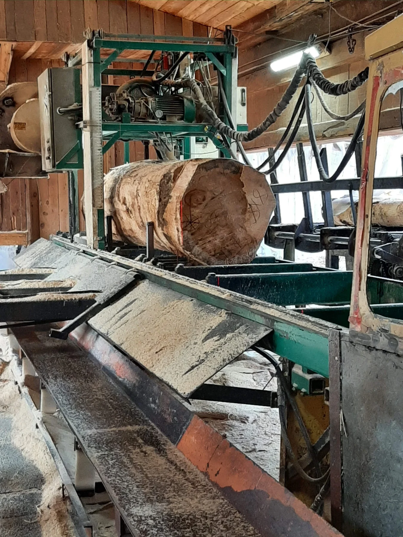 Bille de bois et équipements à l’intérieur de la Scierie Ste-Sophie.