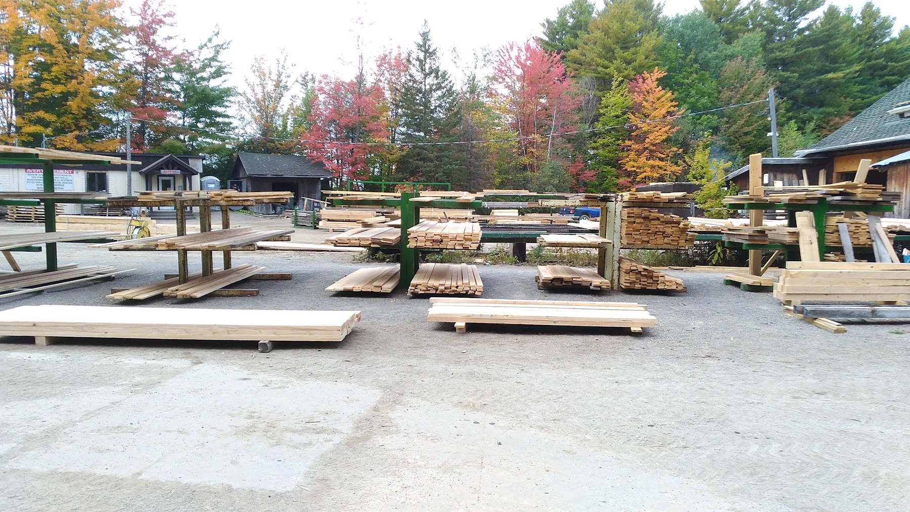 La cour à bois de la Scierie Ste-Sophie, ses bâtiments et ses présentoirs de bois.